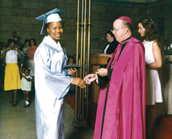 Archbishop George J. Biskup poses for a picture with St. Mary Academy graduate Dana Chatman of Indianapolis during commencement exercises in this undated archive photo. The academy was closed in 1977. (Archive photo)