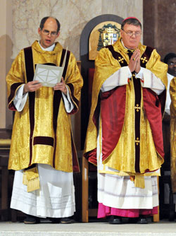 Deacon Russell Woodard, left, reads the general intercessions during the Dec. 3 installation Mass of Archbishop Joseph W. Tobin, right, as the sixth archbishop of Indianapolis in SS. Peter and Paul Cathedral in Indianapolis. Deacon Woodard is parish life coordinator of St. Anne Parish in New Castle and St. Rose of Lima Parish in Knightstown. He also is involved in the ministry of charity at the New Castle Correctional Facility. (Photo by Sean Gallagher)