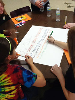Grade school students compose an anti-bullying pledge during a program at Cathedral High School in Indianapolis. (Submitted photo)