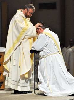Father Eric Johnson ritually lays hands on transitional Deacon Jerry Byrd during a June 1, 2012, Mass at SS. Peter and Paul Cathedral in Indianapolis. Deacon Byrd was ordained a priest during the liturgy. Father Johnson was at the time archdiocesan vocations director. (File photo by Sean Gallagher)