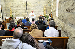 Couples participating in the “One in Christ” marriage preparation program listen as Msgr. Joseph Schaedel, pastor of St. Luke the Evangelist Parish in Indianapolis, explains the Mass in the parish’s chapel on April 13. (Photo by Natalie Hoefer)