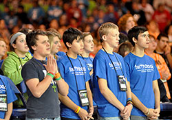 National Catholic Youth Conference participants, from left, Isaac Owen, Tommy Gunderson, Andrew Eilert and Steven Gunderson from St. John the Baptist Parish in Beloit, Kan., in the Diocese of Salina, Kan., pray during the closing Mass on Nov. 19, 2011, at Lucas Oil Stadium in Indianapolis. (File photo by Mary Ann Garber)