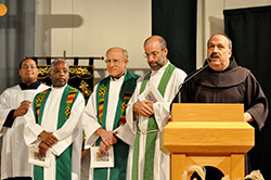 Franciscan Brother Moises Gutierrez, at right, welcomes the congregation as seminarian Douglas Hunter, left, and Fathers Kenneth Taylor, Steven Schwab and Todd Goodson listen at St. Monica Church in Indianapolis on Nov. 3. Brother Moises is the director of the archdiocesan Office of Multicultural Ministry, which sponsored the St. Martin de Porres feast day Mass. (Photo by Natalie Hoefer)