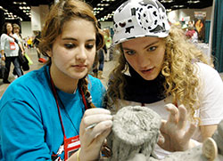 Sarah Bishop, left, and Carmen Miller of the Archdiocese of Indianapolis work together to sculpt a clay image of Jesus during the National Catholic Youth Conference in Indianapolis on Nov. 21. (Photo by John Shaughnessy)