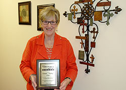 Annette “Mickey” Lentz shows the 2014 Woman for All Seasons Award that she received from the St. Thomas More Society of Indianapolis on Oct. 2. The society honored Lentz, the chancellor of the archdiocese, for her commitment to promote justice in the community. (Photo by John Shaughnessy)