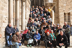 After walking the Way of the Cross in Old City Jerusalem on Feb. 11, pilgrims pose on steps that used to lead to the Chapel of Golgotha in the Church of the Holy Sepulcher.