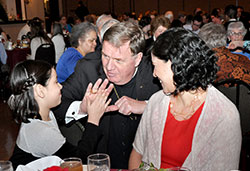 Archbishop Joseph W. Tobin gives a high-five to 7-year-old Sara Cabrera as the girl’s mother, Maria Hernandez, smiles during the annual Sanctity of Life Dinner on March 11 in Indianapolis. Sara, a second-grader at West Newton Elementary School and a member of St. Ann Parish, both in Indianapolis, wrote a letter to President Barack Obama encouraging him to change his pro-abortion stance and become a pro-life president. (Photo by Natalie Hoefer)