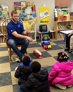 Indianapolis Colts’ tight end Jack Doyle reads a book to children during a visit to the Holy Family Shelter in Indianapolis on March 17. (Submitted photo)