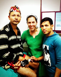 Dr. Christine Groves, who grew up in Christ the King Parish in Indianapolis, poses with a patient, left, that she helped, and his son. Groves is in the midst of committing at least three years of her life to use her medical skills in physical rehabilitation to care for people in the impoverished Asian country of Nepal. (Submitted photo)