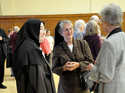 Three sisters from different orders in various locations across central and southern Indiana share stories in the Archbishop Edward T. O’Meara Catholic Center in Indianapolis during a reception for all consecrated religious in the archdiocese on Sept. 13. They are Carmelite Sister Martha Hall of the Carmelite Monastery in Terre Haute, left; Franciscan Sister Martha Ann Rich of the Franciscan Sisters of Perpetual Adoration, who serves at St. Francis Hospital in Indianapolis; and Providence Sister Marilyn Herber of the Sisters of Providence at Saint Mary-of-the-Woods, who currently lives and volunteers in Indianapolis. (Photo by Natalie Hoefer) 