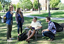 Madison Kinast, left, leader of the Fellowship of Catholic University Students (FOCUS) team at DePauw University in Greencastleand FOCUS team member James Marra, far right, talk with DePauw students Mary Ann Etling and Grant Potts on the university’s campus on Sept. 21. (Photo by Natalie Hoefer)