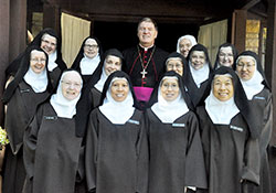 Members of the Discalced Carmelite Monastery of St. Joseph in Terre Haute pose on Oct. 10 with Archbishop Joseph W. Tobin on the monastery’s grounds. Earlier that day, Archbishop Tobin was the principal celebrant of a Mass at the monastery that marked the 500th anniversary of the birth of St. Teresa of Avila, who founded the women’s branch of the Discalced Carmelites. (Photo by Sean Gallagher)