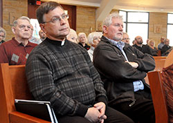 Father Daniel Staublin and Deacon Michael East attend a Feb. 4 press conference at St. Bartholomew Church in Columbus in which Archbishop Joseph W. Tobin announced decisions regarding the Connected in the Spirit planning process for the Bloomington, Connersville and Seymour deaneries. Father Staublin is pastor of Our Lady of Providence Parish in Brownstown and St. Ambrose Parish in Seymour. Deacon East ministers at both of the Seymour deanery faith communities. (Photo by Sean Gallagher)