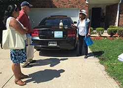 Two Legion of Mary members, left, involved in a door-to-door evangelization effort at St. Monica Parish in Indianapolis on July 27 listen to the prayer intentions of a woman living within the boundaries of the parish after providing her with material about the Catholic Church and St. Monica Parish. (Photo by Natalie Hoefer)