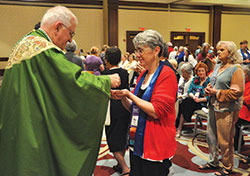 Sharon O’Brien, director of the Catholics for Family Peace Education and Research Initiative at the Catholic University of America in Washington, receives Communion from Archbishop Joseph E. Kurtz during the Sept. 10 closing Mass of the National Council of Catholic Women convention held at the Downtown Marriott in Indianapolis. (Photo by Sean Gallagher) 