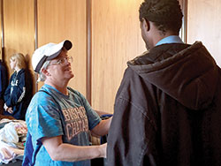 Benedictine Sister Kathleen Yeadon helps a man at the Cathedral Kitchen on Oct. 19. The theology teacher at Bishop Chatard High School in Indianapolis brought students of her social justice class to volunteer. (Photo by Natalie Hoefer)