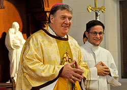 Cardinal-designate Joseph W. Tobin laughs while making closing remarks during a Nov. 9 Mass at Bishop Simon Bruté College Seminary in Indianapolis. Assisting at the Mass as an altar server is Eric Gehlhausen, right, a seminarian of the Diocese of Evansville, who is a junior at Bishop Bruté. (Photo by Sean Gallagher)
