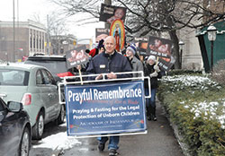 Ken Ogorek, archdiocesan director of catechesis, leads a precession along North Meridian Street in Indianapolis on Jan. 22, 2016, during last year’s solemn prayerful remembrance of the Supreme Court’s Roe v. Wade decision that legalized abortion. This year’s Mass and procession will take place on Jan. 23. (Criterion file photo by Natalie Hoefer) 