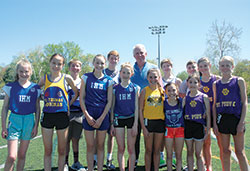 Catholic Youth Organization director Ed Tinder poses for a photo with some of the participants in the Indianapolis North Deanery CYO track meet at Bishop Chatard High School on April 23. Tinder will be retiring in mid-June. (Photo by John Shaughnessy)