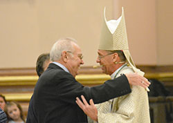 Archbishop Charles C. Thompson shares a smile and a hug with his father Coleman Thompson as family members presented the offertory gifts to the archbishop during his installation Mass at SS. Peter and Paul Cathedral in Indianapolis on July 28. (Photo by Natalie Hoefer)