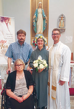 Sister Solanus Casey Danda, center, poses on July 11 in St. Theresa Church in Corpus Christi, Texas, with her parents, Richard and Katherine Danda, and her brother, Father Sean Danda, after professing perpetual vows as a member of the Society of Our Lady of the Trinity. (Submitted photo)