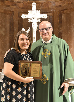Emily Taylor, a 16-year-old-member of Holy Spirit Parish in Indianapolis, receives the archdiocesan Our Lady of Guadalupe Pro-Life Youth Award from Msgr. William F. Stumpf, archdiocesan vicar general, at SS. Peter and Paul Cathedral in Indianapolis on Oct. 1. (Photo by Natalie Hoefer)