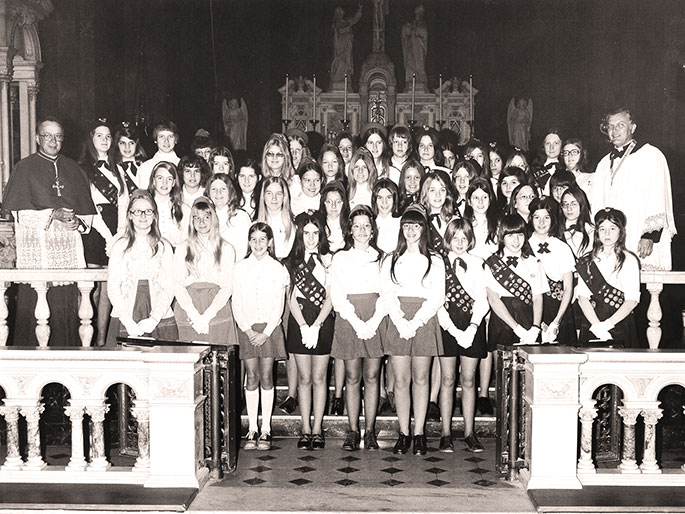 This photo shows the church dedication program committee for the former St. Ann Parish in Terre Haute in 1953. St. Ann Parish was founded in 1876 and had occupied a number of different church buildings. From 1906 to 1953, their parish was served by a building which housed a school on the first floor and the church on the second floor. On Nov. 1, 1952, the parish broke ground for a new church building, which was dedicated on June 21, 1953. St. Ann Parish closed in 2012 as part of the “Connected in the Spirit” planning process.