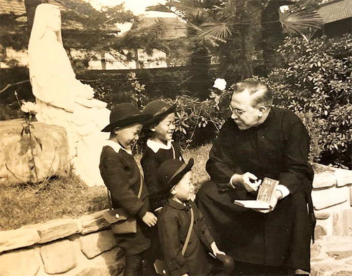 In this photo, Maryknoll Father Clarence Witte reads to children in Japan. Father Clarence, a native of Richmond, was ordained a Maryknoll missionary priest in 1935. He served in Japan from 1947-66, including a five-year term as the regional superior of priests of his order in Japan. Following his assignment in Japan, Father Clarence was sent to Bolivia to minister to Japanese immigrants. In 1976, he returned to Japan, where Father Clarence remained until his retirement and death in 2001. His autobiography, titled Quod est Demonstrandum: What It’s All About, was reviewed by Archbishop Daniel M. Buechlein in his weekly column in The Criterion on Sept. 28, 2001.