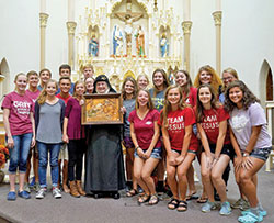 Benedictine Mother Dolores Hart, center, holds an image of the Holy Family given to her by members of St. Louis Parish in Batesville and poses with members of the parish’s youth group on Sept. 30. Created by the local Weberding’s Carving Shop, the image was a gift to the nun who visited the parish and shared her life story. (Submitted photo by Katie Rutter)