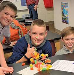 Harrison Howell, left, Evan Nevitt, and McKinley Combs, all sixth-graders at St. John Paul II School in Sellersburg, smile after winning a competition in their STEM class in the New Albany Deanery school. (Submitted photo)
