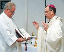 Altar server Tim Spreitzer of SS. Peter and Paul Cathedral Parish in Indianapolis holds the Missal for Archbishop Charles C. Thompson during a March 18 Mass celebrated during a Catholic Charities statewide conference at the Wellington Conference Center in Fishers, Ind., in the Lafayette Diocese. (Photo by Mike Krokos)
