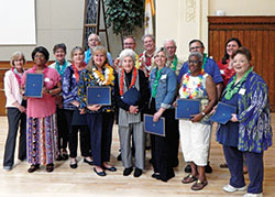 Among those recognized for years of service during the Catholic Charities Indianapolis volunteer dinner on May 16 at the Archbishop Edward T. O’Meara Catholic Center in Indianapolis are: front row, Lorette Morgan, left, Iris Parrish, Sue Sandefur, Rita Tomson, Jessica Limeberry, Valerie Cook and Debbie Whitaker. Back row: Charlene Glawe, left, Margaret Voyles, Mike Parrish, Deacon Michael Braun, archdiocesan executive director of Catholic Charities David Bethuram, Robert Hughes, Tom Kueper and Jaqueline Pimentel-Gannon, president of the Catholic Charities Indianapolis Agency Council. (Photo by Mike Krokos)