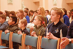 Juan Martinez-Gaspar, left, Paul Chrisman, Rosanna Spearing and Elizabeth Roller, all students at Holy Name School in Beech Grove, kneel in prayer on Jan. 29 during a Catholic Schools Week Mass in SS. Peter and Paul Cathedral in Indianapolis. Several hundred Catholic school students from across central and southern Indiana took part in the liturgy. (Photo by Sean Gallagher)