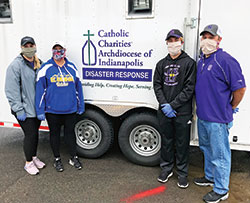 Peyton Levine, left, Michelle Neibert-Levine, and Andrew and Matt Levine, members of St. Ambrose Parish in Seymour, pose on April 23 beside a food truck donated by the archdiocesan Catholic Charities Disaster Response office to help feed the growing number of hungry families and individuals through Waymaker Ministries’ “Feed Seymour” effort. Neibert-Levine is principal of St. Ambrose School. (Submitted photo)
