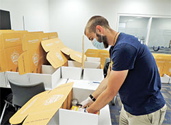 Marian University mentor Joel Kelley double checks the contents of a Missionary Discipleship Institute participant’s box before it is sealed. (Submitted photo)