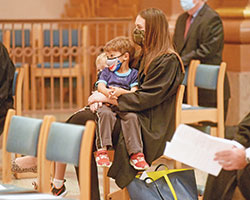 Marion County Superior Court Judge Jennifer Harrison sits with her sons Rory (partially obscured) and Henry during the annual Red Mass of the St. Thomas More Society of Central Indiana, celebrated on Oct. 7 at SS. Peter and Paul Cathedral in Indianapolis. (Photo by Sean Gallagher)