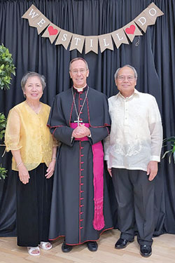 Celia and Domingo Conlu, members of St. Simon the Apostle Parish in Indianapolis, pose for a photograph with Archbishop Charles C. Thompson during a reception in the Archbishop Edward T. O’Meara Catholic Center in Indianapolis after the archdiocese’s 38th annual Wedding Anniversary Mass on Aug. 14 across the street at SS. Peter and Paul Cathedral. The couple has been married for 50 years. (Submitted photo by Richard Corona)
