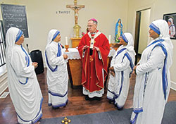 Archbishop Charles C. Thompson speaks on Sept. 21 with the four members of the Missionaries of Charity who minister in Indianapolis after celebrating Mass for them in the chapel of their Our Lady of Peace Convent. The sister are, from left, Sister Emerita, Sister Paulinus, Sister Janita and Sister Kiron Jyoti. (Photo by Sean Gallagher)