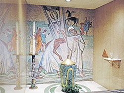 Peter Recker created the mosaic work for the church’s baptistry and the triangular bronze ambry installed in the right-side wall, and also designed the baptismal font. “The mosaic is of [St.] Philip baptizing the Ethiopian,” as told in Acts 8:26-40, says Caleb Legg. “It’s another nod to the African American, symbolizing that Blacks have been part of the Catholic faith from the very beginning of Christianity.” As for the bronze ambry, Legg notes that Recker “created all the bronze works in the church.” (Submitted photos by Caleb Legg)