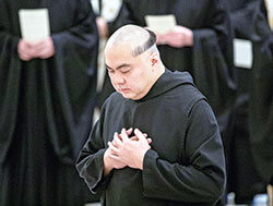 Benedictine Brother Michael Reyes kneels in prayer during a Jan. 25 Mass at the Archabbey Church of Our Lady of Einsiedeln during which he professed solemn vows as a member of Saint Meinrad Archabbey in St. Meinrad. He also shows the traditional haircut, known in Latin as “corona” (“crown”) given to monks at the monastery when they enter the novitiate and profess solemn vows. (Photo courtesy of Saint Meinrad Archabbey)