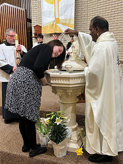 Father Jeyaseelan Sengolraj, administrator of St. Michael Parish in Charlestown, baptizes Haley Cady during the Easter Vigil Mass at St. Michael Church on April 8. (Submitted photos by Jennie Lathem)