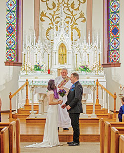 Deacon Michael East witnesses the exchange of wedding vows of Blake Davidson, right, a grandson of Deacon East, and Lacy Joslin on Oct. 26, 2019, at St. Ambrose Church in Seymour. (Submitted photo)