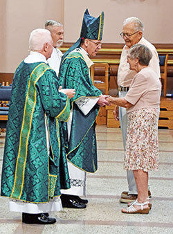 Archbishop Charles C. Thompson shares a word with James and Barbara Vandygriff after they brought forth the offertory gifts during the annual archdiocesan Wedding Anniversary Mass on Aug. 27 at SS. Peter and Paul Cathedral in Indianapolis. The couple, members of St. Rose of Lima Parish in Franklin, celebrated 65 years of marriage. (Photo by Natalie Hoefer)
