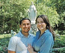 Moses and Kate Tinio pose in front of a shrine at Our Lady of Fatima Retreat House in Indianapolis. Our Lady of Fatima has played a special part in their lives, their engagement and their marriage. (Photo by John Shaughnessy)