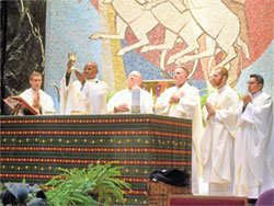 Marianhill Father Jean Bosco Ntawugashira elevates a chalice during a Nov. 3 Mass at St. Rita Church in Indianapolis honoring St. Martin de Porres, a patron saint of racial justice. Joining him as concelebrants at the Mass are, from left, Father Jack Wright, Father John McCaslin, Father Michael O’Mara, Father Vincent Gilmore and Father Jose Neri. (Photo by Sean Gallagher)
