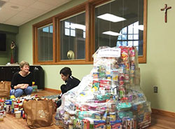 Karen Hanley, left, and Karla Dehner organize food items donated as part of the St. John the Baptist Parish Lenten Food Drive, which benefits the Newburgh Area Food Pantry. Submitted photo.
