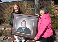 Portrait artist Anne Jones of Crown Point (left) and Munster resident Mary Yates are pictured on April 11 holding a pastel chalk drawing that Jones created for Yates, honoring her deceased son Ryan Andrew Yates, who died at the age of 19 in 2013. Jones is the director of the non-profit Face to Face Art, the mission of which is to serve grieving families through art featuring a dearly departed. (Anthony D. Alonzo photo)
