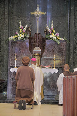 Sister Nancy Frentz prays during the litany of the Mass on the feast of St. Benedict who was himself, a hermit.