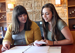 Vicky Hathaway, of Lowell, and Magdalena Barajas, of Valparaiso, review materials from the GIVEN Catholic Young Women's Leadership Forum they attended last month in Washington D.C. Each woman has developed an "action plan" to use their new leadership skills to help the Diocese of Gary. (Marlene A. Zloza photo)