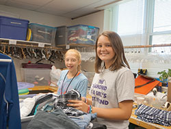 Brooke Hanson and Kaitlyn Garrett volunteer in the clothing room at the St. Vincent de Paul Store in Noblesville. (Photo by Caroline B. Mooney)